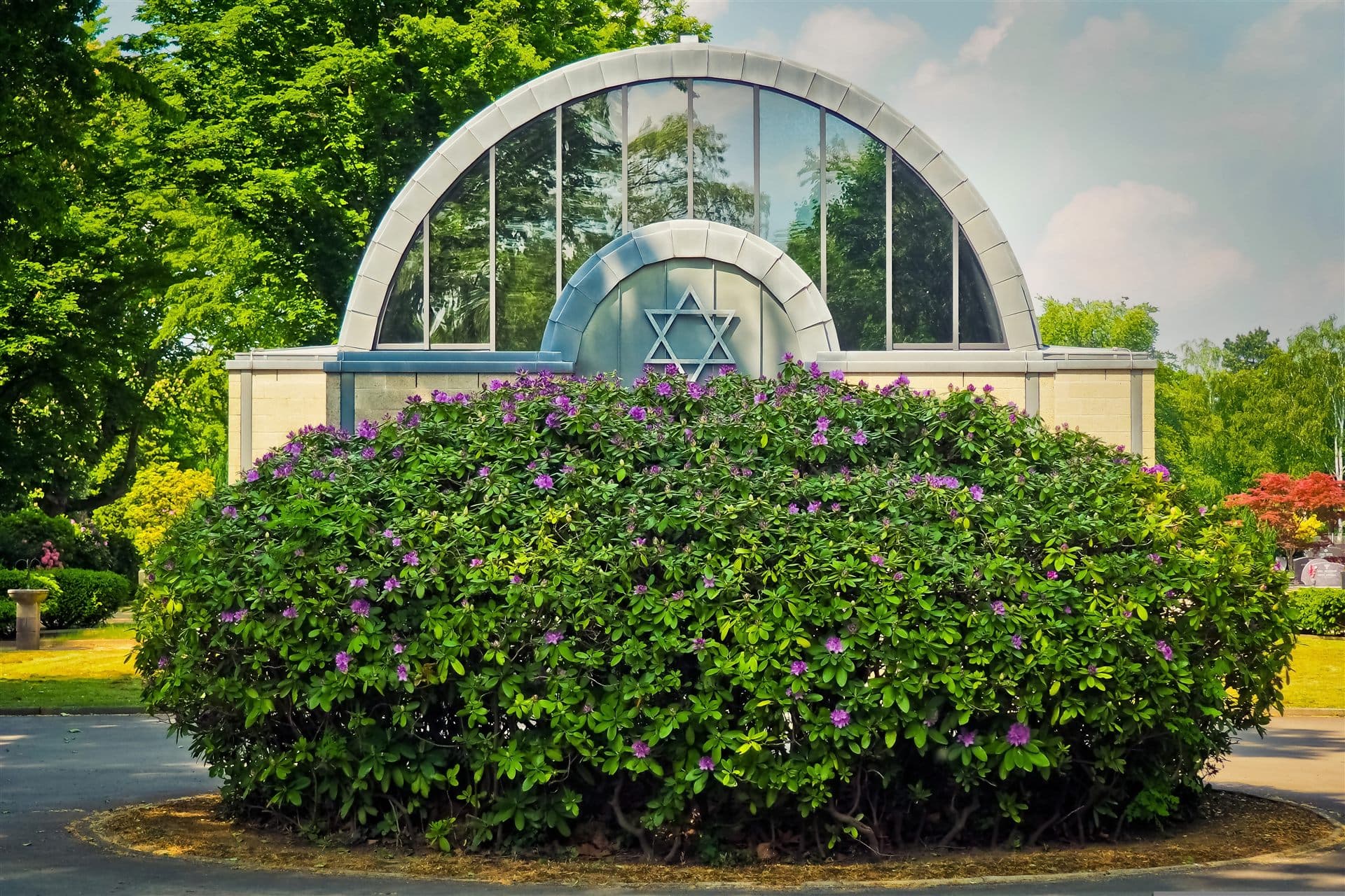 Jewish cemetery chapel with a Star of David surrounded by flowering greenery
